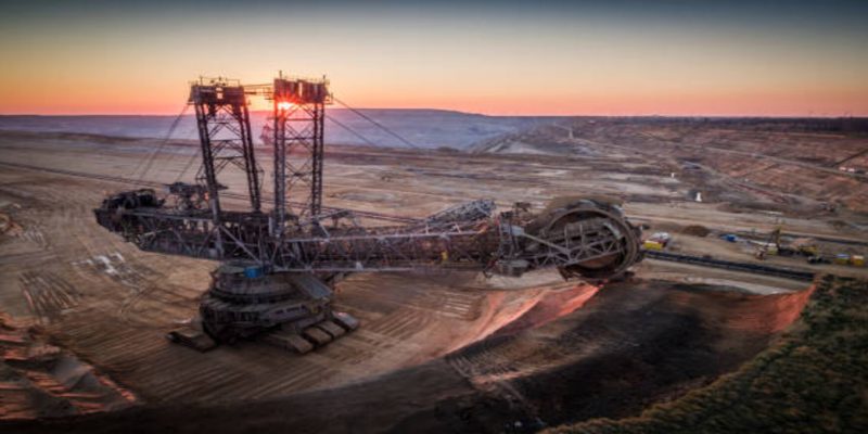 Aerial shot of a giant open pit lignite mine Hambach in Germany. Large bucket excavator mining machinery. Moody light at sunset.